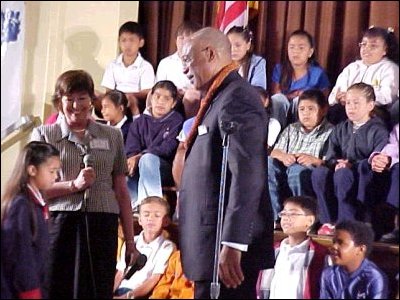 Adrian, a student at Carson Elementary, presents Secretary Paige with a Hawaiian lei.